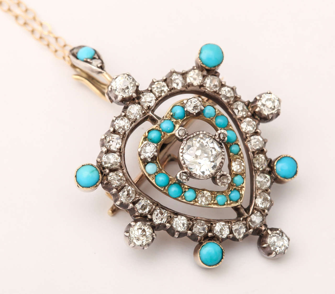 A gift of a lifetime, this exquisite diamond and turquoise antique jewel was made as a pendant and a brooch. Behind the pendant is a pin that ingeniously unscrews so that the heart lays flat at the neck. A photo, untouched, cannot show you the