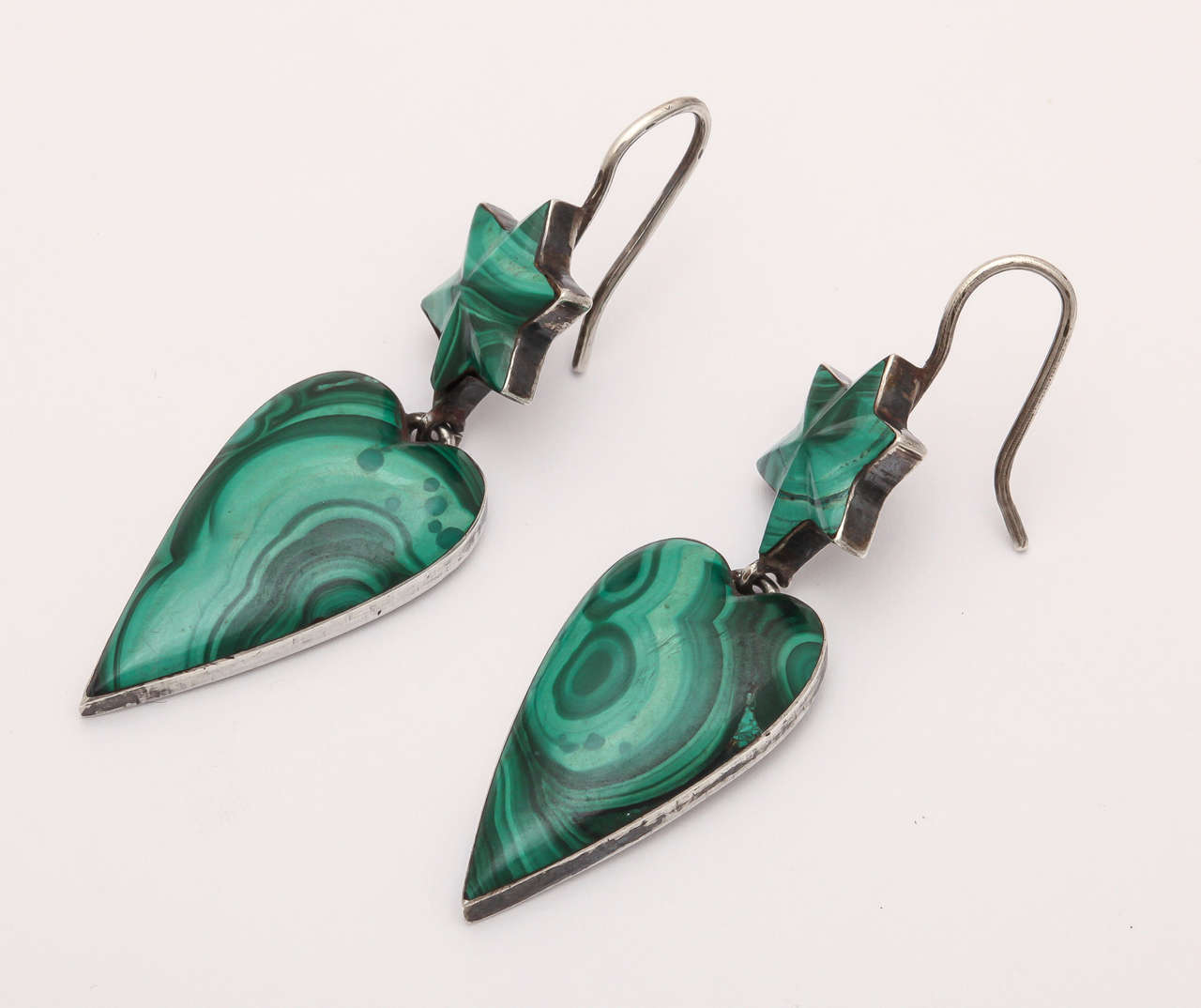 Perpetually wearable earrings fashioned in sterling silver and beautiful malachite stones with its undulating swirls of color.  This is a pair I have seen only now, this once, in 30 years. Stars at the top. Elongated hearts at the bottom. The