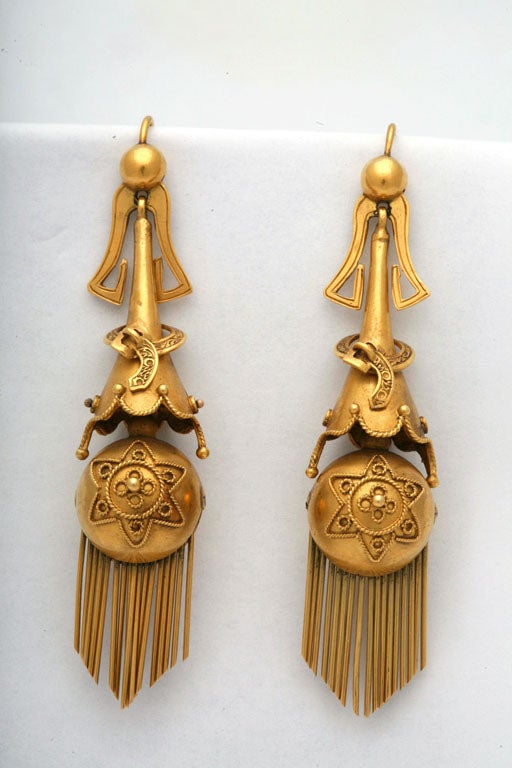 These earrings are beautiful and classic examples of great mid-Victorian jewelry. During the 1860’s, it was popular for women to accessorize with long earrings, and these were meant to be worn during the day, as they are entirely made of gold and