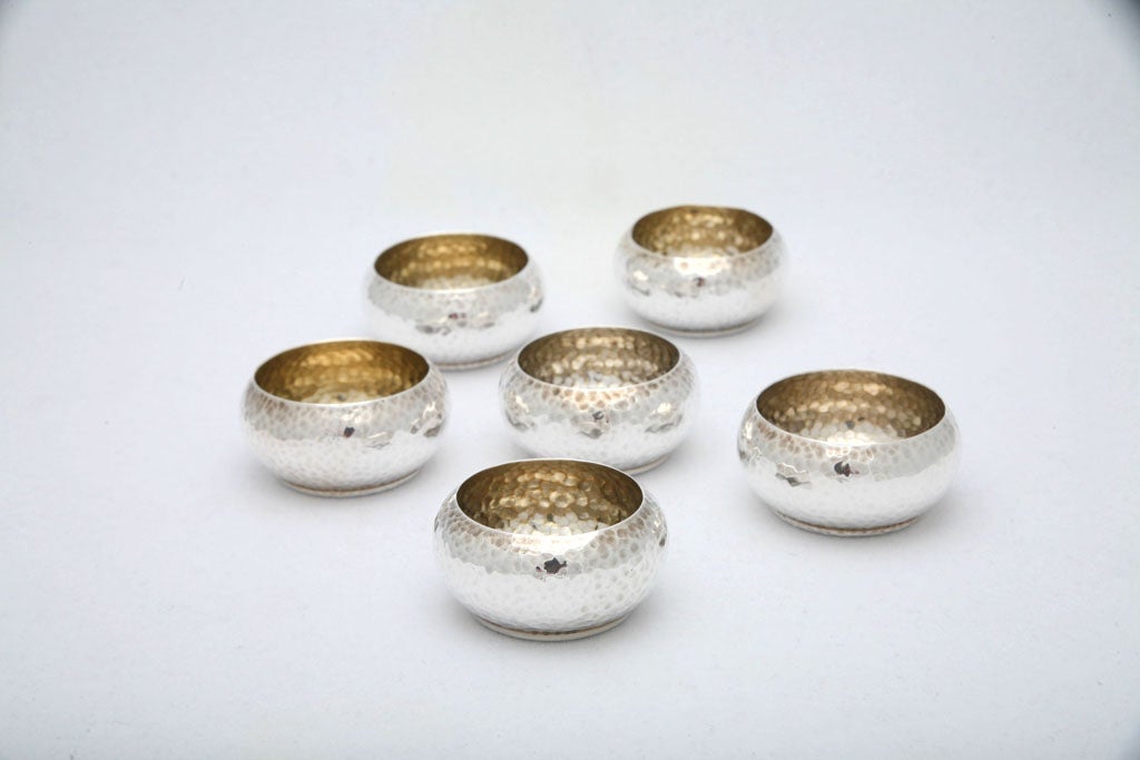 A useful set of salt cellars from Tiffany & Co. Just in time to dress up your holiday table. Each one has a nice hammered finish. Three of the cellars also have a hammered bottom and three do not. Stamped T& Co. Sterling