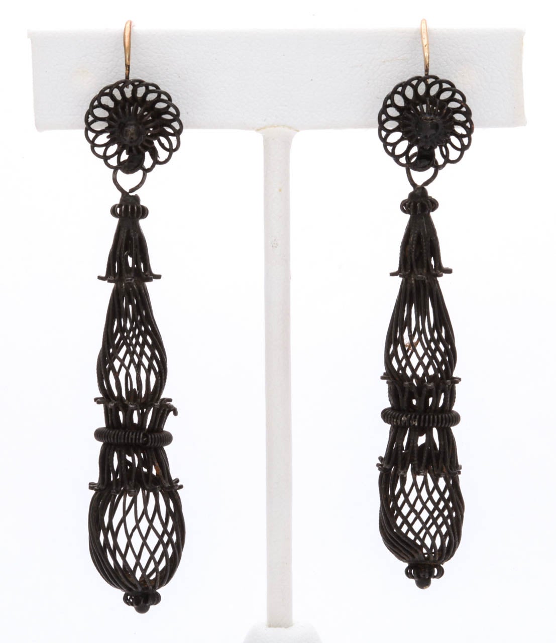 Glorious woven Berlin Iron earrings are light as air and a rare  treasure. Fine strands of iron criss cross forming elongated  cages topped with iron flowers. This is one of the most rare pair of earrings from this prized period. Germany went to the