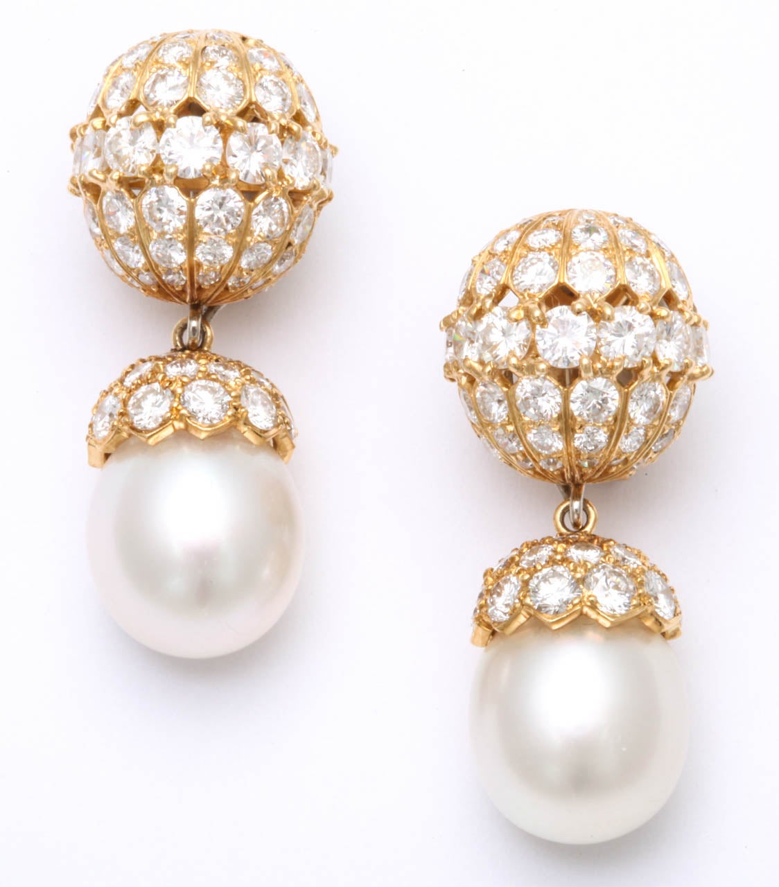 A PAIR OF DIAMOND AND CULTURED PEARL EAR PENDANTS, BY VAN CLEEF & ARPELS. 
Each suspending a detachable cultured pearl, measuring approximately 11.95 mm, with a circular-cut diamond cap, to the circular and single-cut diamond domed surmount,