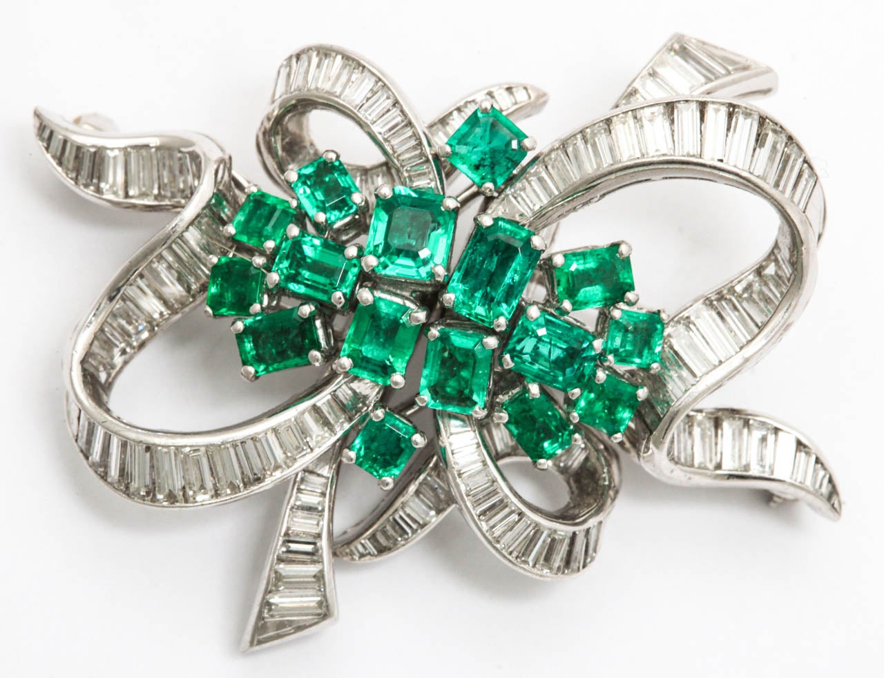 Fluid Ribbon Brooch - separating to a pair of Duet Clips with hand made fitted attachment.  Early 50's and so much of the period.
7.0 cts of Diamond Baguettes - G-H color - VS clarity &  3.5 cts of brilliant Columbian Emeralds set in a handmade