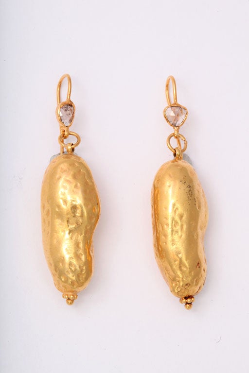 A pair of 18kt yellow gold peanut earrings. The earrings are suspended from 18kt yellow gold and rose cut diamond wires.
Length: 2:00 inches