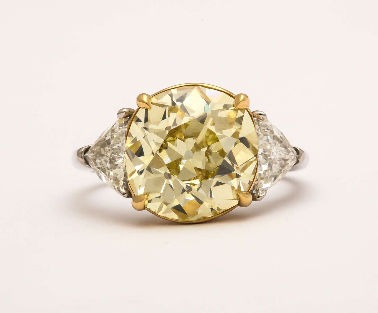 Platinum ring centering an Old Mine Cut diamond 5.22 carats Fancy Yellow and Slightly Imperfect accompanied by GIA report #14566761  flanked by 2 colorless triangle diamonds 1.20 carats