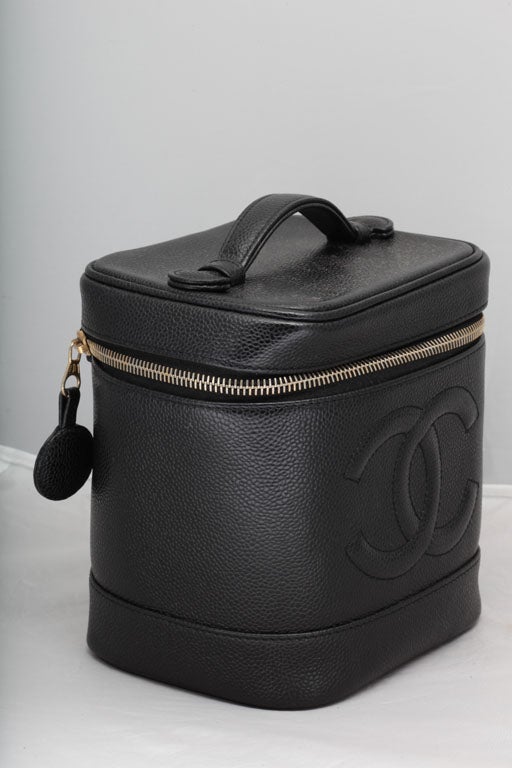 Chanel black caviar skin vanity bag with zipper closure.