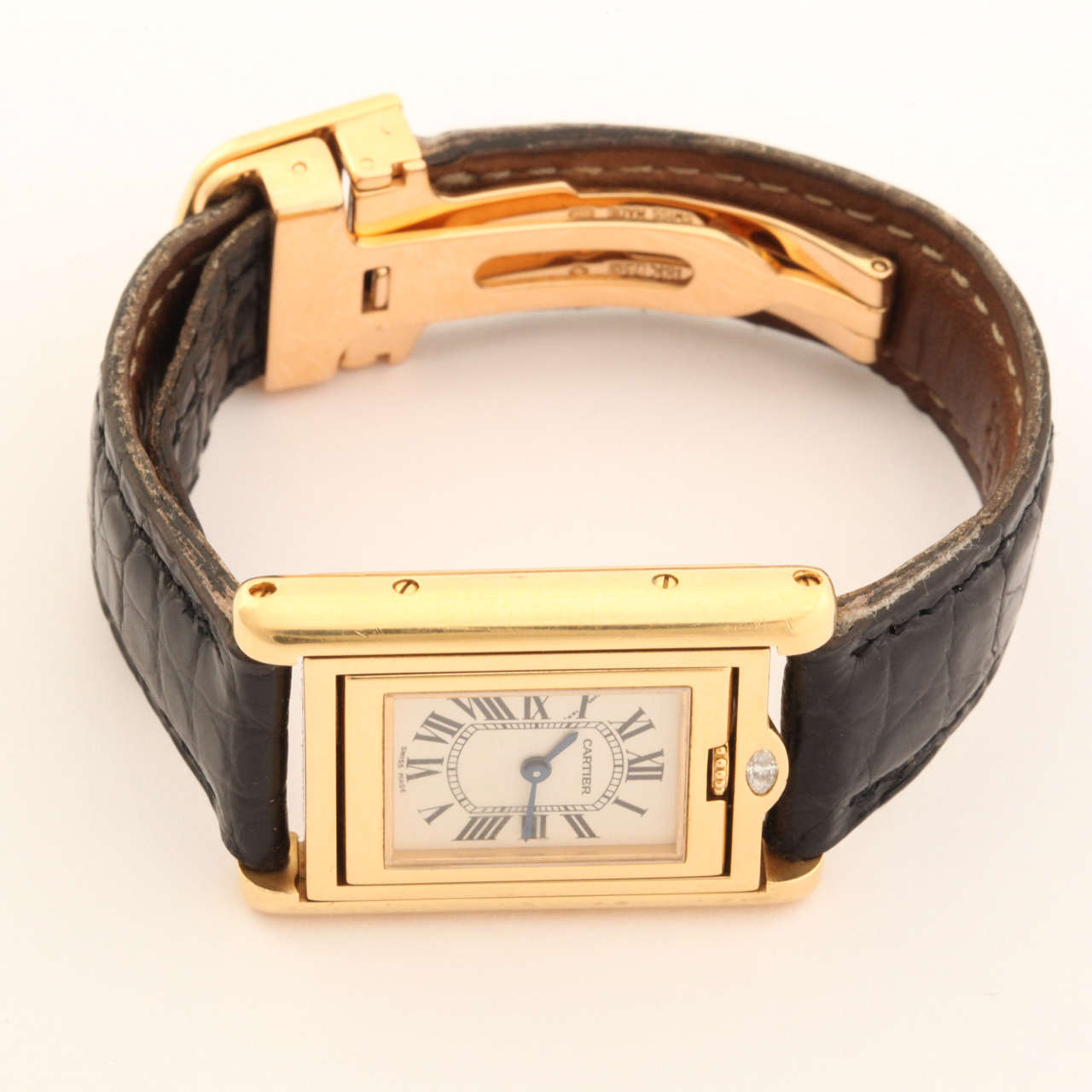 A rare Cartier Lady's 18k Yellow Gold and Diamond Tank Basculante Collection Privee Wristwatch, circa 1999. Instead of the classic sapphire detailing, this watch has a specially cut diamond in its place.  This is the place to lift the reversible the