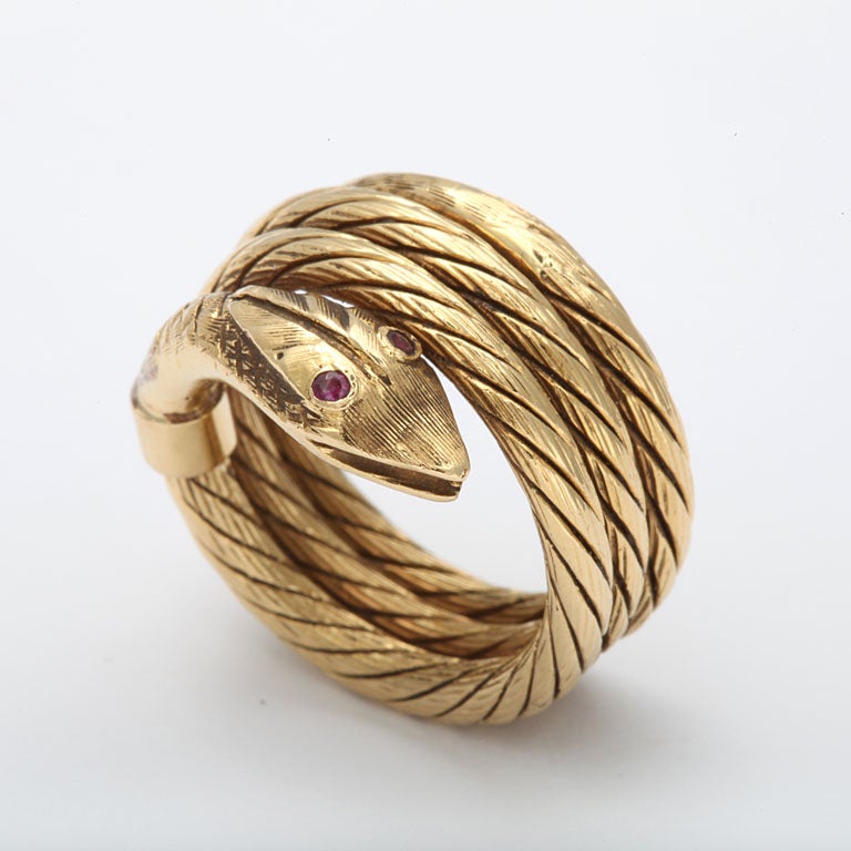 Coiled Serpent Ring with engraved detailing and ruby Eyes made in 18kt Yellow Gold.  Height of the 60's  -Large and prominent and very comfortable.  Size 8 1/2-9.