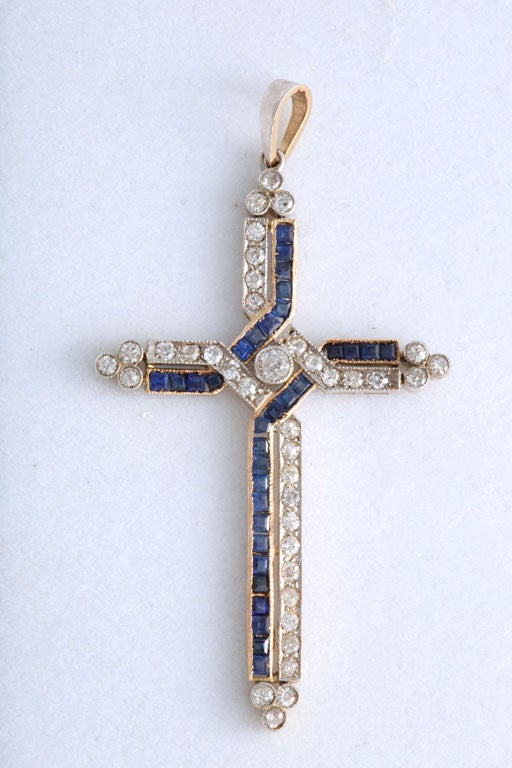 Impressive platinum on gold cross featuring prong set round diamonds and channel set French cut sapphires.  The piece has approximately 1.5 carats in diamonds.
