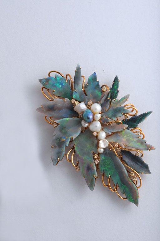 This large brooch features floral hand carved Mintabie black opal plaques, cognac diamonds, and baroque freshwater pearls set in a handmade 18k mounting.

It measures approximately 4.5