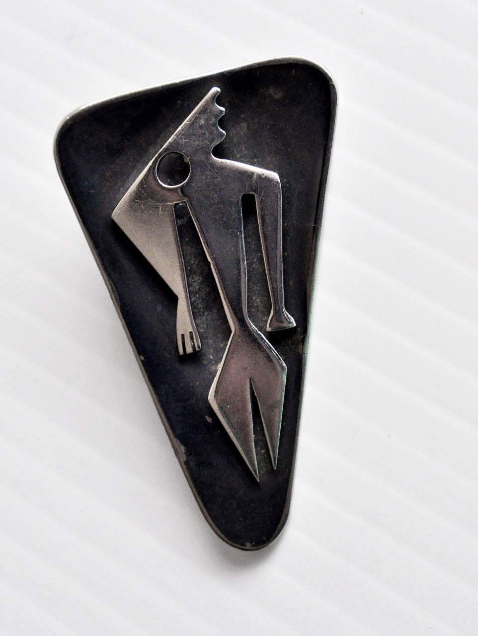 A sculptural sterling silver pendant by Ed Wiener reflecting the artist's interest in primitive imagery.

Reference:  Jewelry by Ed Wiener (definitive catalog on Ed Wiener published in conjunction with the retrospective exhibition
