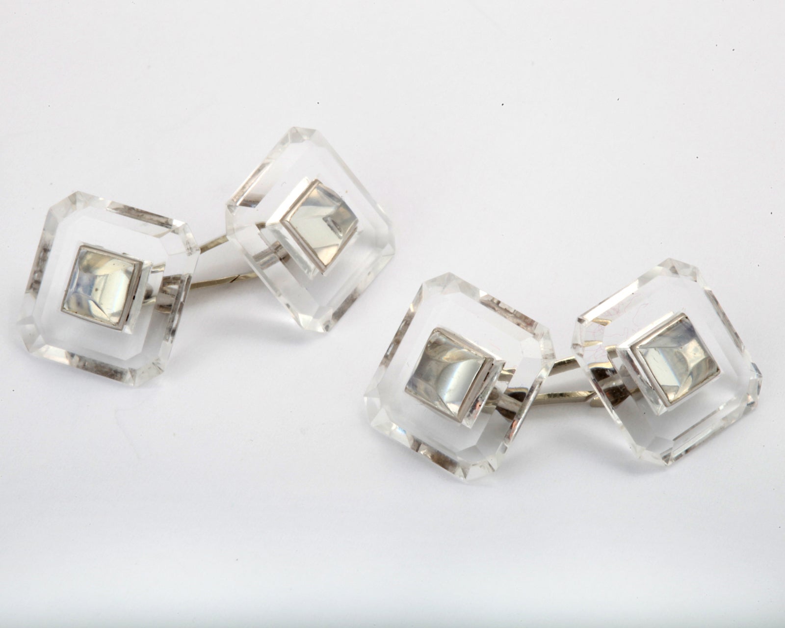Beautifully cut rock crystal cuff links are set with carved moonstones. Superbly crafted and exceptionally stylish the cuff links are set with 14kt white gold fittings.