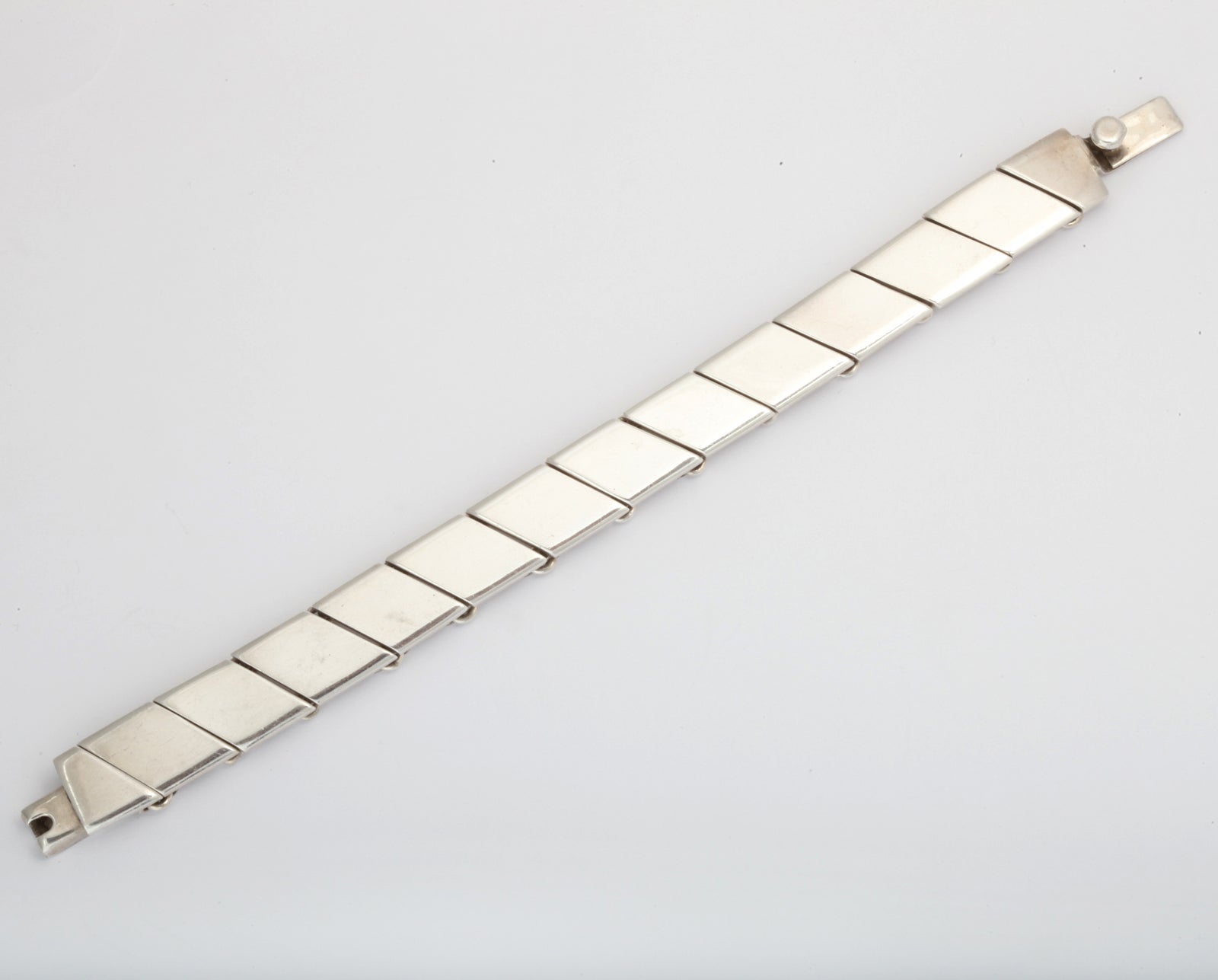 A beautiful link bracelet made up segmented diamond shaped pieces which almost appear faceted. Very simple design and sits beautifully on the wrist alone or stacked with other bracelets. Marked T5-134 for Taxco, Mexico and 925.