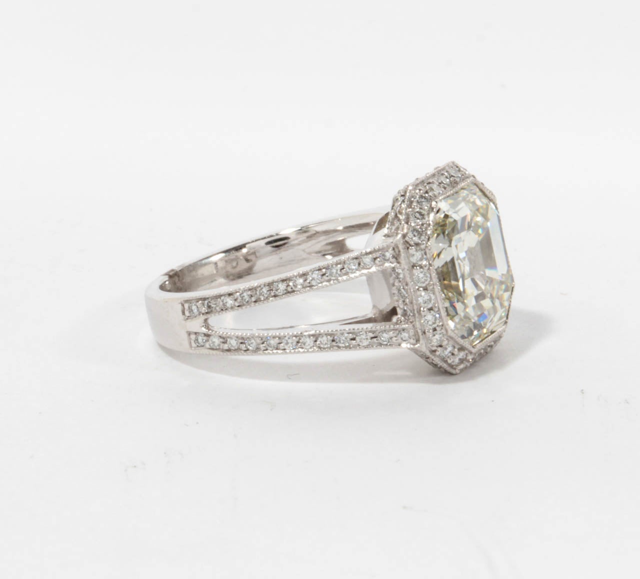 Ein schöner Diamant in der Mitte und ein individuell gestalteter Ring.

5.28 Karat Asscher-Schliff - Farbe H - Reinheit VS2 Zertifizierter zentraler Diamant. 

1.20 Karat runde Diamanten im Brillantschliff, gefasst in einer individuell