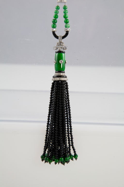 This magnificent sautoir has a tassel composed of 24 strands of onyx beads, each with 1 jade bead at the bottom. Connected to the chain composed of alternating barrel-shaped jade beads, with diamond-set platinum at each end, and tube-shaped sections