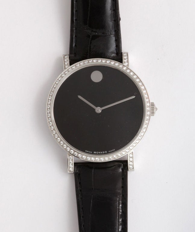 Classic Movado large black faced watch with automatic movement, surrounded by diamonds and with Movado alligator strap.