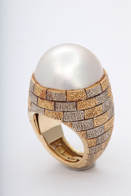 18kt White & Yellow Gold Hammered  & Crenelated Mounting holding a 20mm Mabe Pearl.  Size 5 1/2+, as there is an internal sizer which can be eliminated.