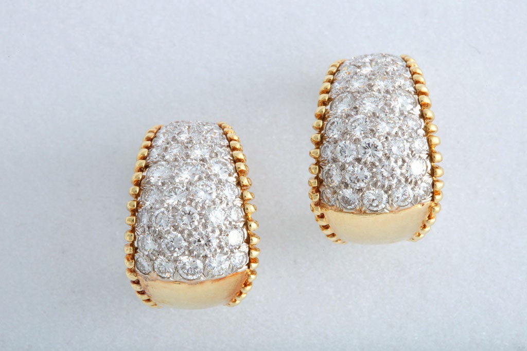 Il présente environ 5 carats de diamants sertis en pavé montés dans un élégant design en or jaune 18k avec des bords perlés.  Ces boucles d'oreilles sont munies d'un clip et n'ont pas de tige.