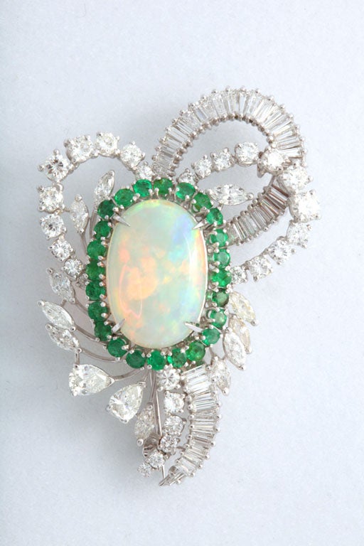 Beautiful custom made platinum brooch.  Featuring a 22c Crystal Opal in an emerald and diamond frame.  The photo does not do the opal justice.  It has incredible vibrant play of color - very nice broad flashes on red, green, yellow, and blue. The