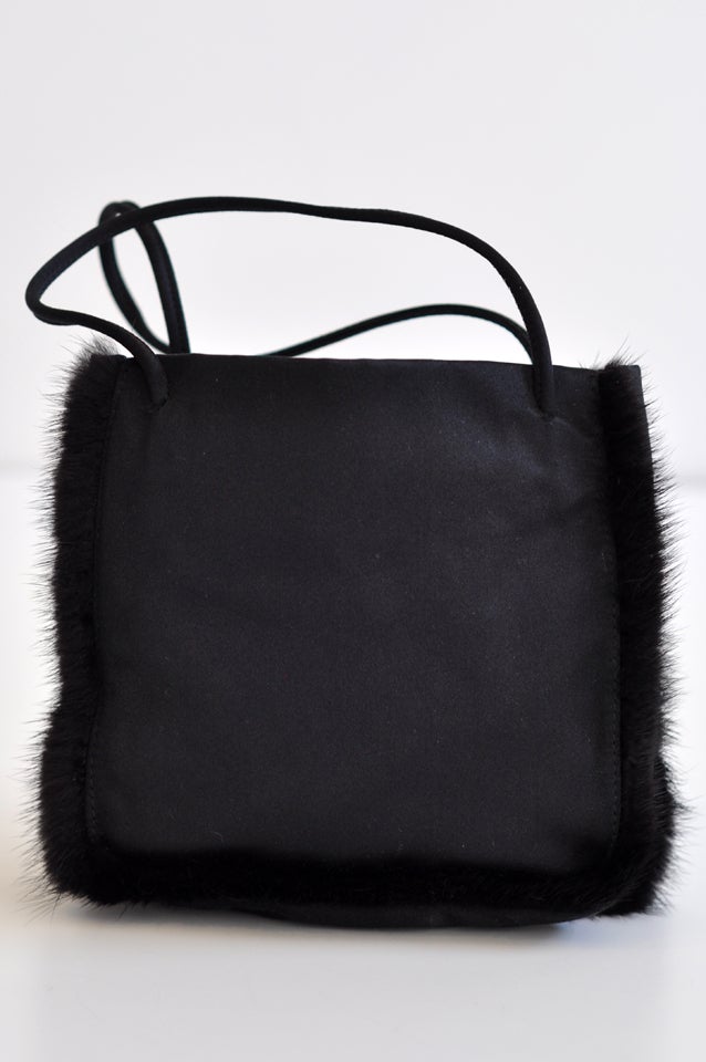 Luxurious satin evening purse with black mink trim and  an open top with interior pocket with velcro closure. An elegant small tote bag from Prada.  