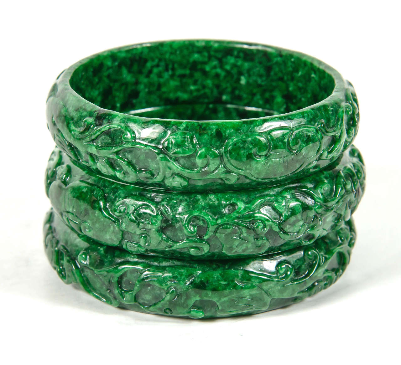 These elegant classic design bracelets feature a stylized hand carved stylized foliage design all out of a single piece of jade.These were purchased in Hong Kong in 1970.