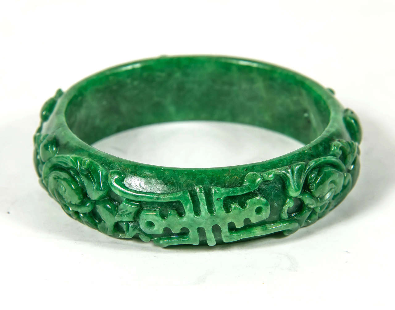 This hand carved Chinese Stone  bracelet feature a stylized floral and scroll design executed in fine hand carved jade.