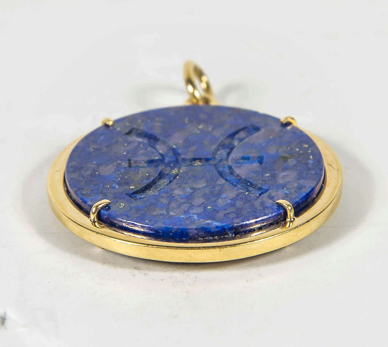 This charm is signed by Aldo Cipullo made of hand carved Lapis with the Pisces zodiac symbol carved into it.This piece is framed in 18k yellow gold and would be great as a pendant or on a charm bracelet.
