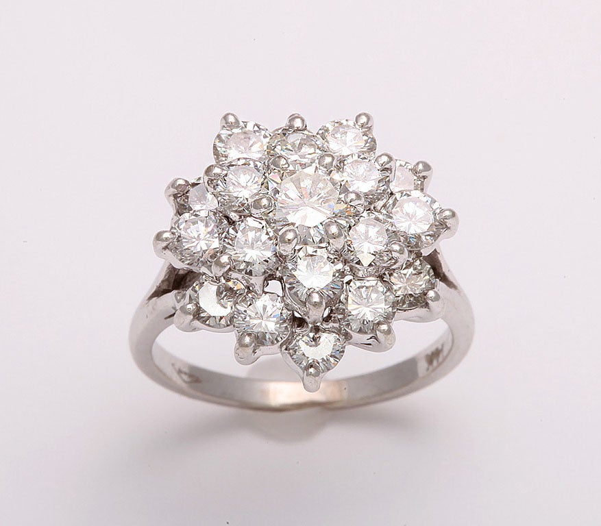 This beautiful ring has a .65c diamond in the center with approximately 2 more carats surrounding it. This popular design has been produced since the 1950's.  The diamonds are mounted in 14k white gold.<br />
<br />
Size 6 3/4