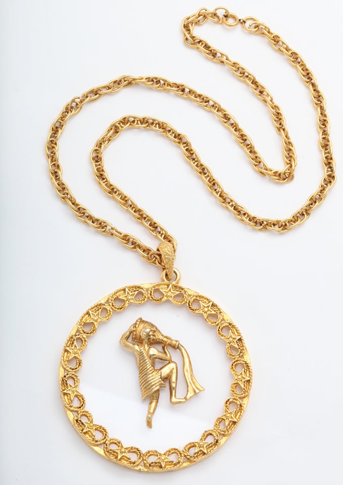Gold tone metal and lucite Aquarius medallion necklace. Chain is 22