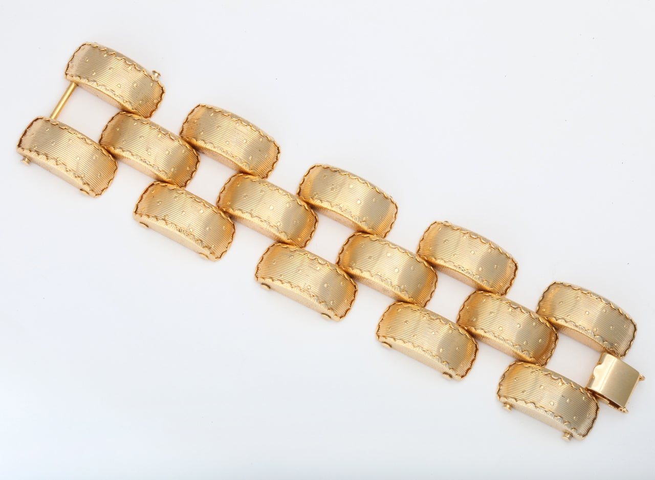 A large cuff-like bracelet having ribbed and dotted links with scalloped edges.