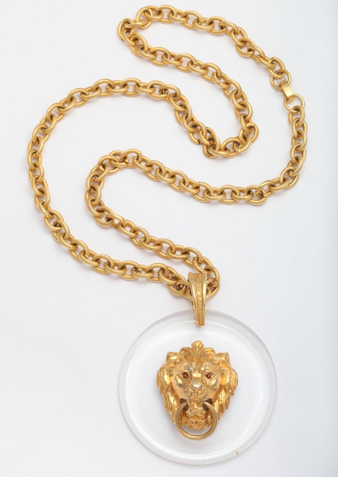 Lion head mounted on a lucite disk with a substantial goldtone chain. Chain length is 25