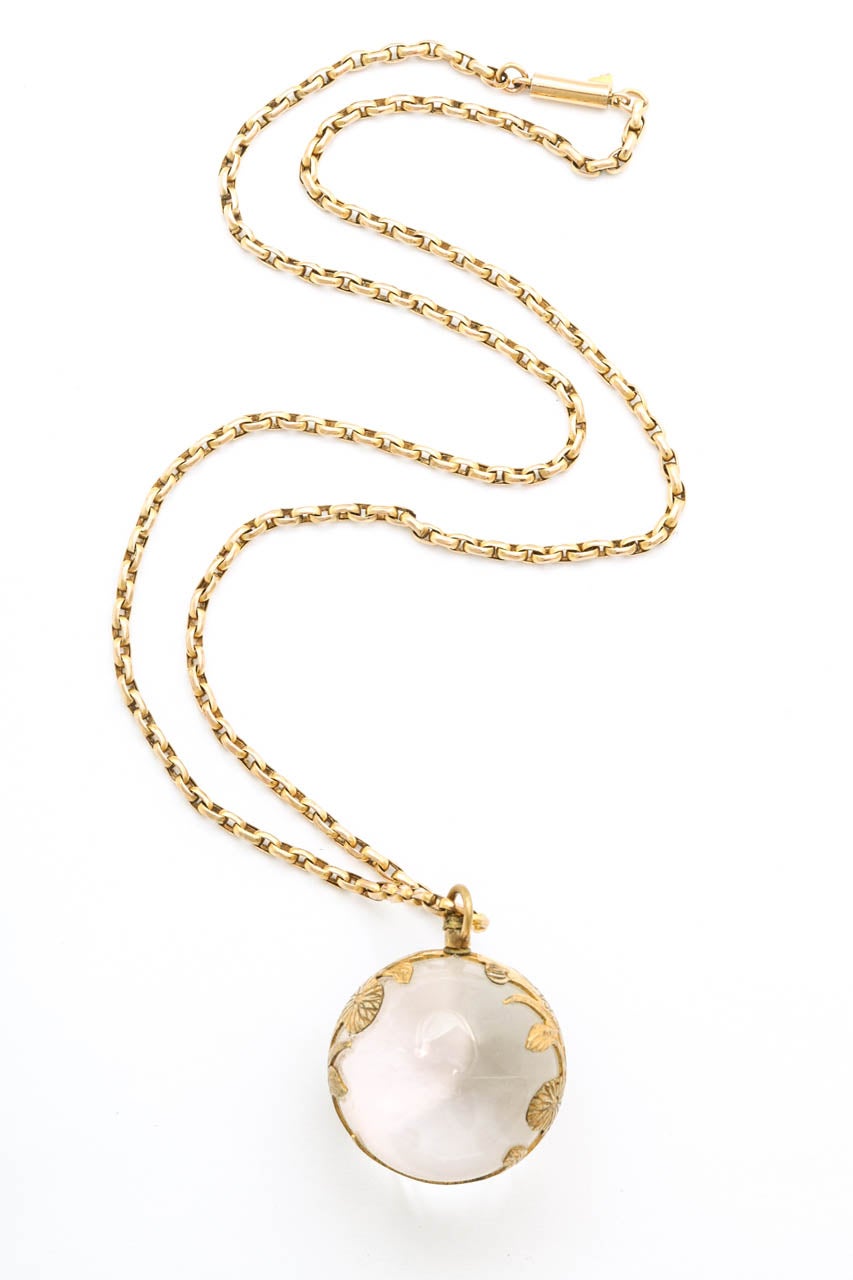 Anhänger mit Bergkristallkugel:: umhüllt von einer goldenen Blumenapplikation. Der Kristall ist makellos. Der Anhänger stammt aus der Zeit zwischen 1860 und 1870. Der Bergkristall ist der Edelstein für 10-jährige Jubiläen. Ihm werden magische und