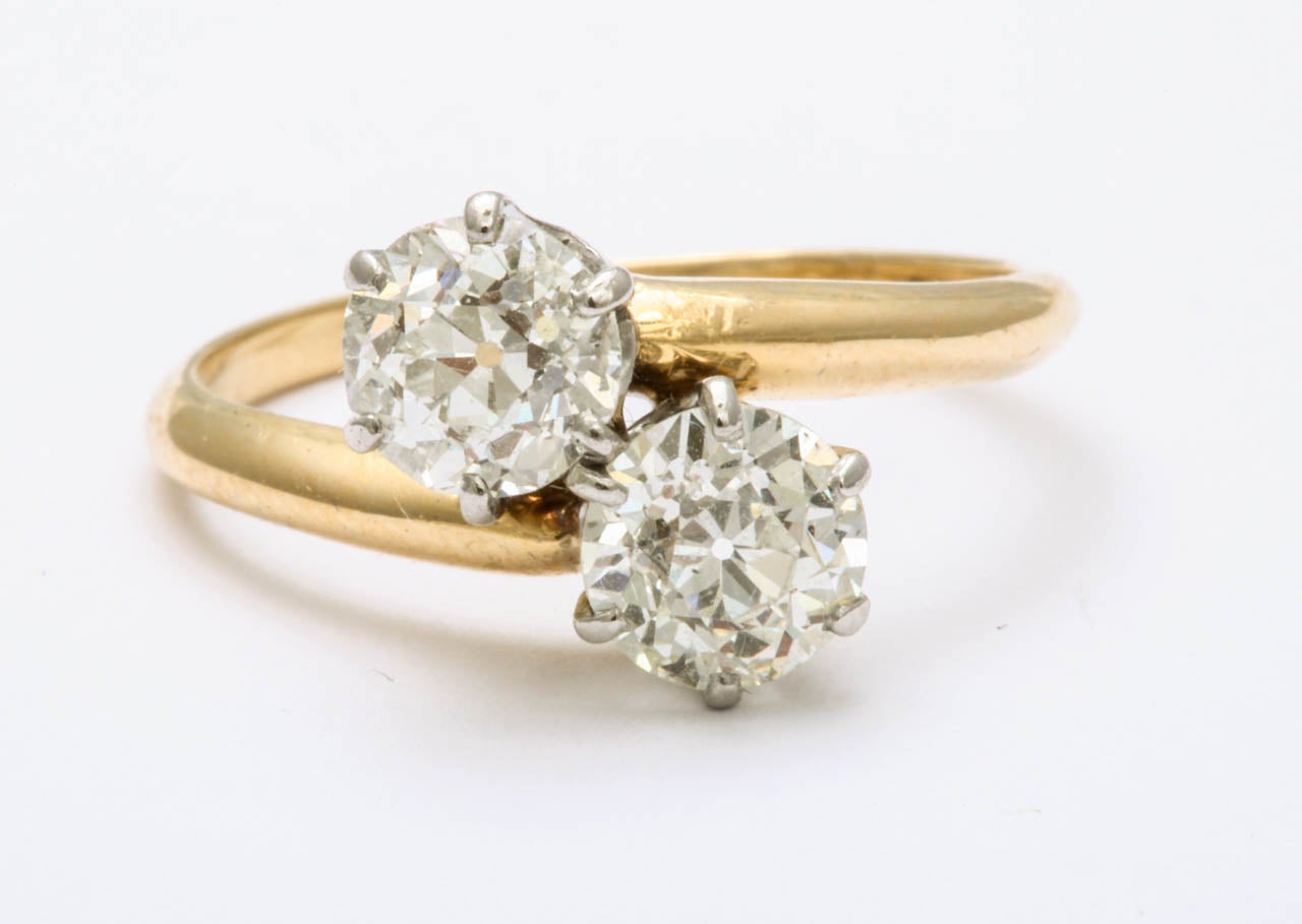 Lovely Antique ring featuring two round diamonds weighing approximately 1.50 carats, in yellow gold.