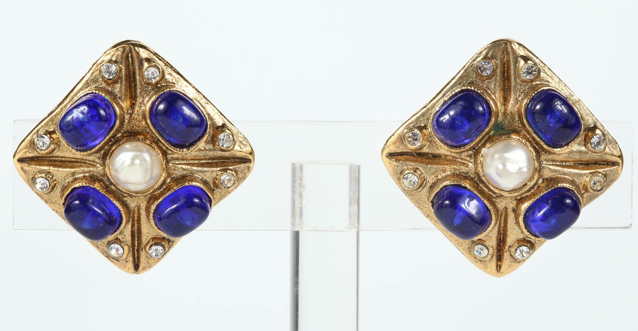 A chic and vibrant pair of Chanel ear clips featuring cobalt poured glass, a central glass pearl and rhinestones set in a gilt metal diamond. Marked on the back with the 