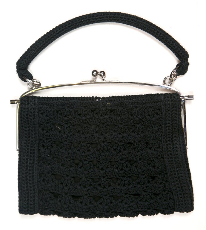 From funkyfinders is a Dolce & Gabbana black crochet handbag. its chrome kisslock closure and frame highlight the piece. the interior is lined in a semi-sheer textile with a 'Dolce & Gabbana' 'made in Italy' nameplate, and houses 1 large compartment.