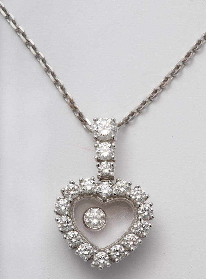 Signed Chopard Happy Hours Diamond Pendant set with 14 full cut clean & white Diamonds  & Diamond  Bezel set in encased crystal Heart suspended with 3 graduated Diamonds.  Chain & Heart - 18kt & signed & numbered