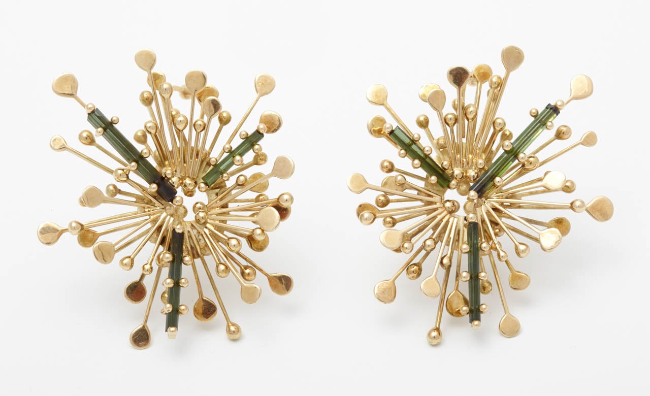 A pair of gold and tourmaline earclips by Anneke Schat
Designed as a stylised sunburst highlighted by three baguette tourmalines. Makerâ??s mark for Anneke Schat.

All of our prices exclude VAT.