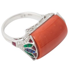 A Coral, Calibré Cut Ruby, Emerald, Sapphire and Diamond Platinum Dress Ring.