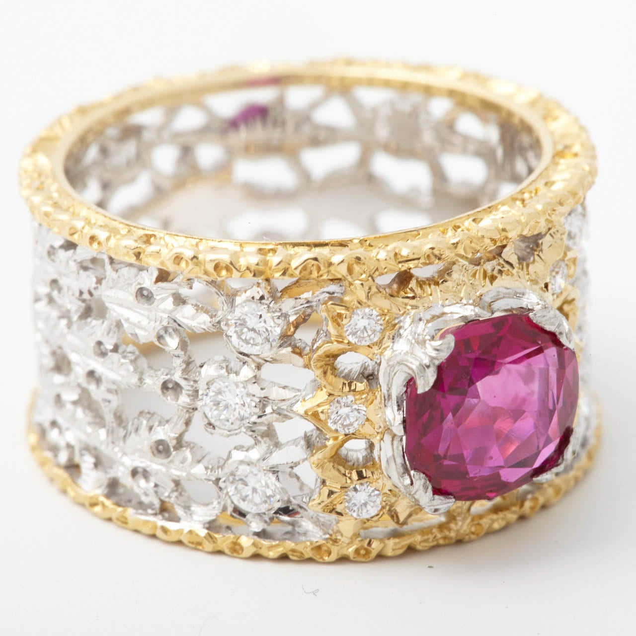 The mixed cushion-shaped Burmese ruby weighing  1.88 ct, to a pierced yellow and white gold band decorated with leaf motifs,  set with brilliant-cut diamonds weighing approximately 0.20 ct.  Engraved Federico Buccellati. Accompanied by a NEL Report