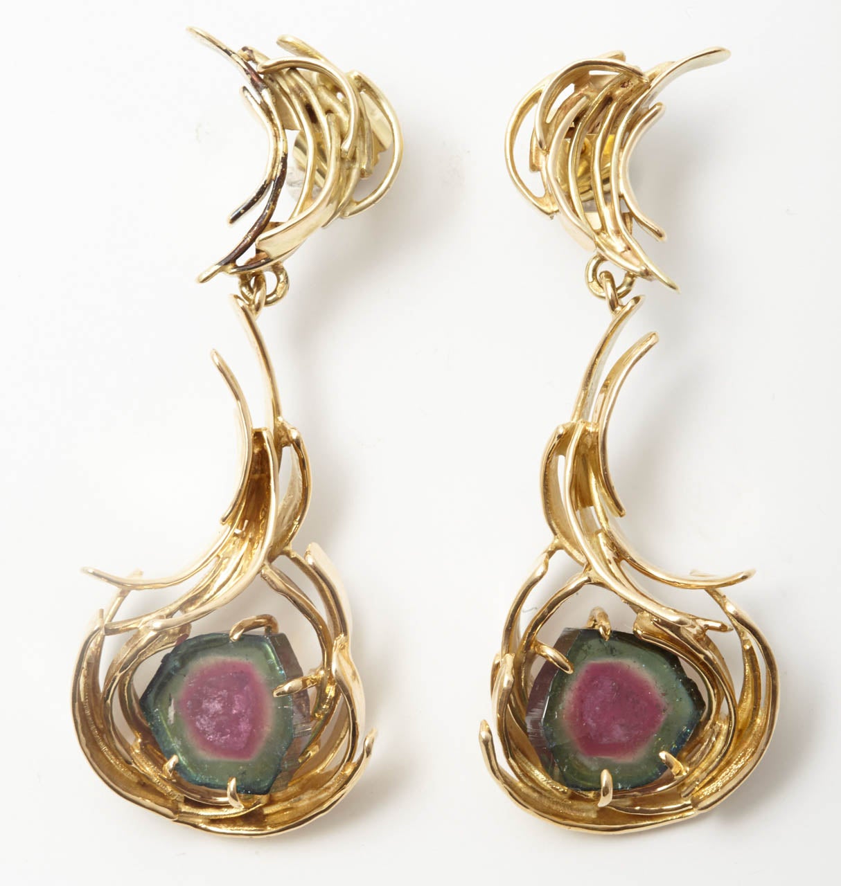 A pair of gold, tourmaline earrings by Anneke Schat
Each designed as a free form of 14K yellow gold curved bars, highlighted by a water melon tourmaline plaque to the centre. Signed Anneke Schat.

All of our prices exclude VAT.