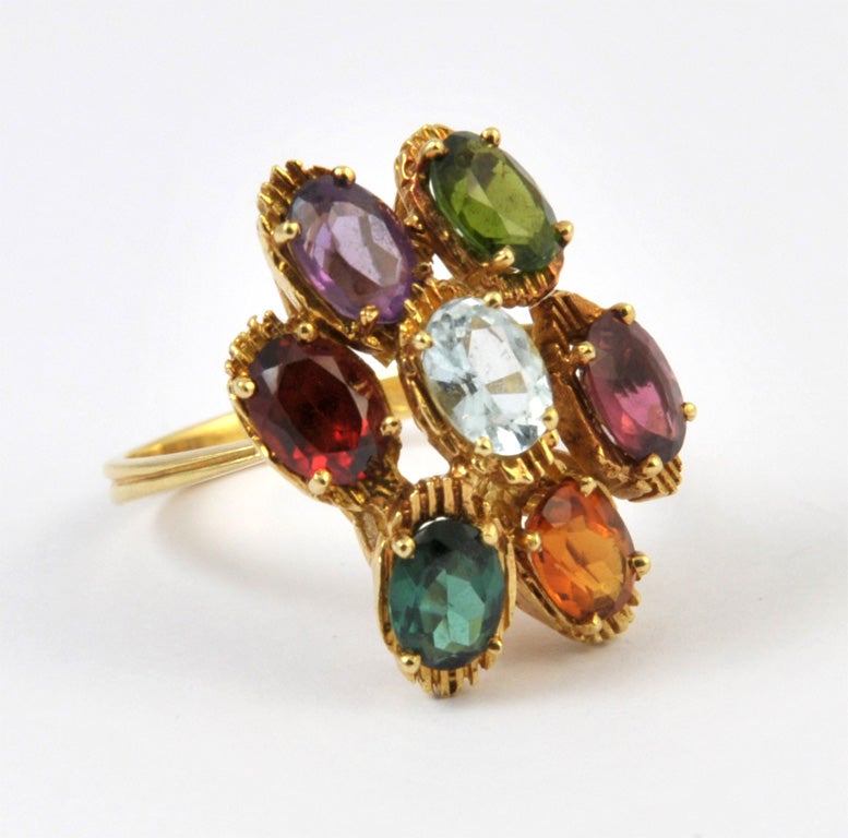 An 18 K yellow chiseled gold ring signed by Stern set with 7 stones for approx. 7 ct : 1 amethyst, 1 garnet, 3 tourmalines, 1 citrine and 1 aquamarine.