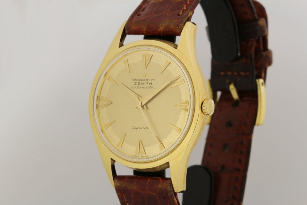 Dies ist ein großartiges Beispiel für eine Zenith Captain Armbanduhr aus 18k Gelbgold aus den 1950er Jahren. Sie ist mit dem Stoßfänger-Automatikwerk Kaliber 133.8 von Zenith ausgestattet. Das Gehäuse und das Zifferblatt dieser Uhr sind beide