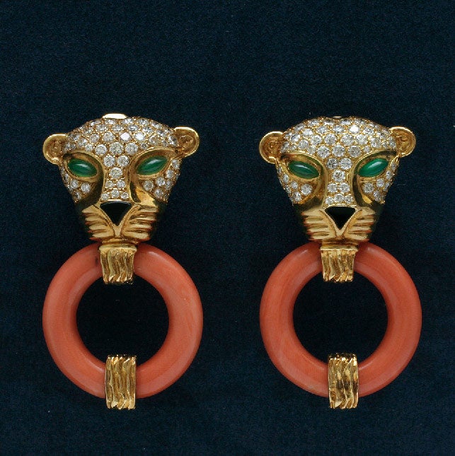 This pair of diamond leopard clip earrings has sculptured green onyx eyes, and faceted black onyx nose. The Coral hoop is designed as a hinged door knob. The cute leopard heads are made of 14 kt gold. They are sexy, provocative and distinctive