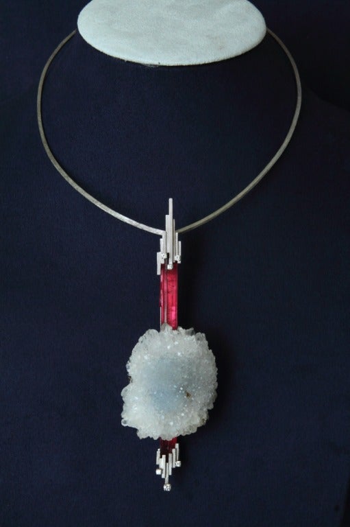 This pendant is a juxtaposition of nature and design, rustic, and clean. Royal British designer Andrew<br />
Grima cleverly combines the pink tourmaline and crystal agate into a sculptural pendant highlighted<br />
with six diamonds. Adorn