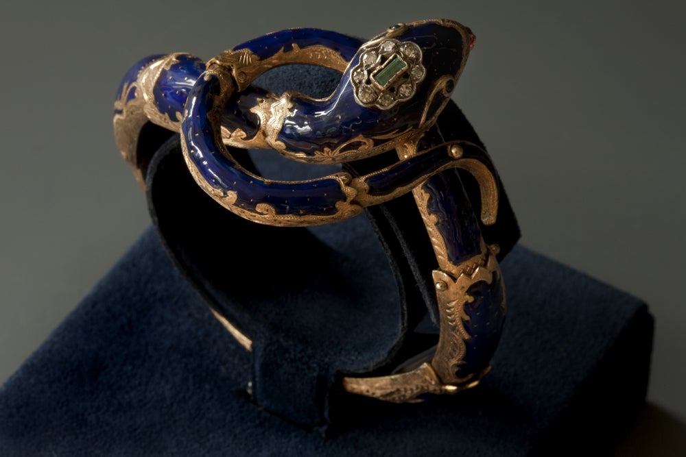 Georgian period bracelet on your wrist or upper arm. Erotic yet tasteful. An elegant enameled snake with its head resting on a curved tail. The head is topped with a baguette cut emerald, surrounded by diamonds and the tongue is made of garnet.