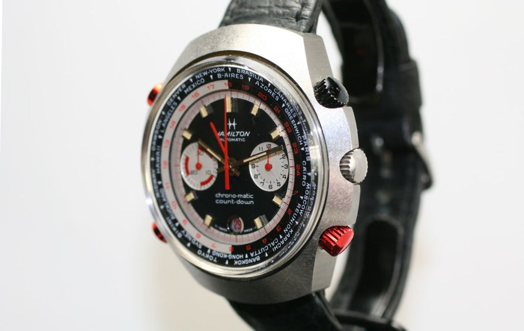 This Hamilton Count-Down GMT Chronomatic chronograph wristwatch has a large 48mm satin-finish stainless steel case, anodized red and black buttons and features an additional GMT hand and two crowns used to rotate 24h and time-zone bezel rings.