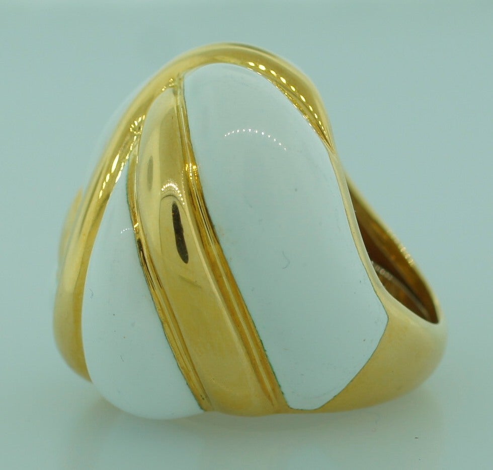 Bold and prominent cocktail ring created by Andrew Clunn in the 1980's. It is made of yellow gold and white enamel. The enamel work is very fine.
The ring is size 6.5 and due to the inner sizer-ring can fit a smaller finger.
