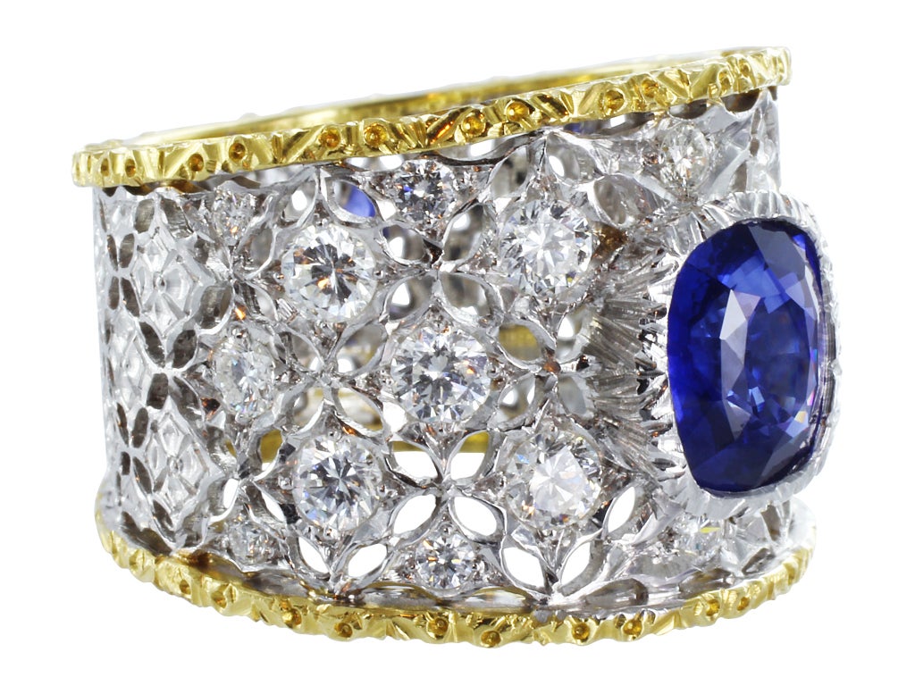 Two tone 18 karat yellow and white gold open work ring consisting of 1 cushion cut blue sapphire weighing approximately 1.40 carats set with 1.00 carats total weight of full cut diamonds accents, signed M. Buccellati.