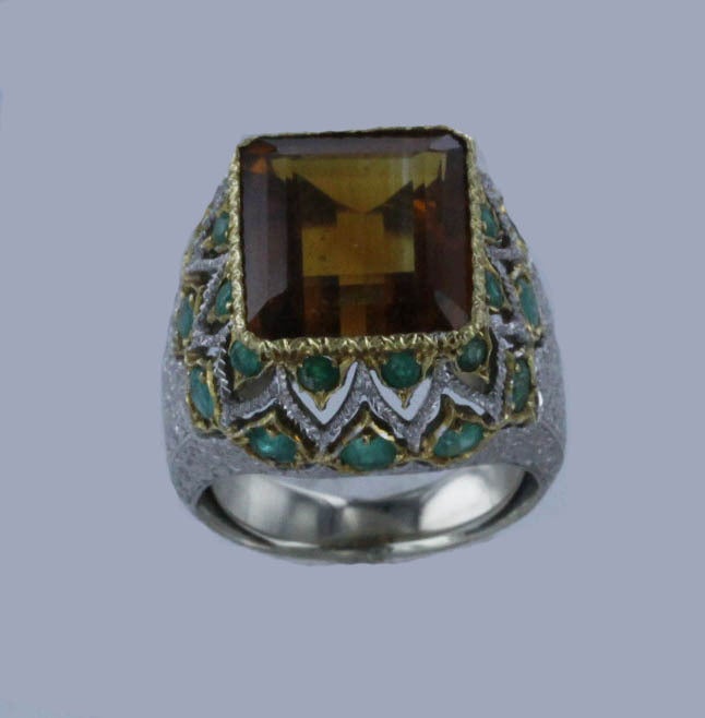 A stunning example of complex Bucellati craftsmanship, this ring showcases a dramatic square-cut, 8 ct. citrine surrounded by 24 round emeralds set into delicate white-gold fretwork. Numbered 18090.