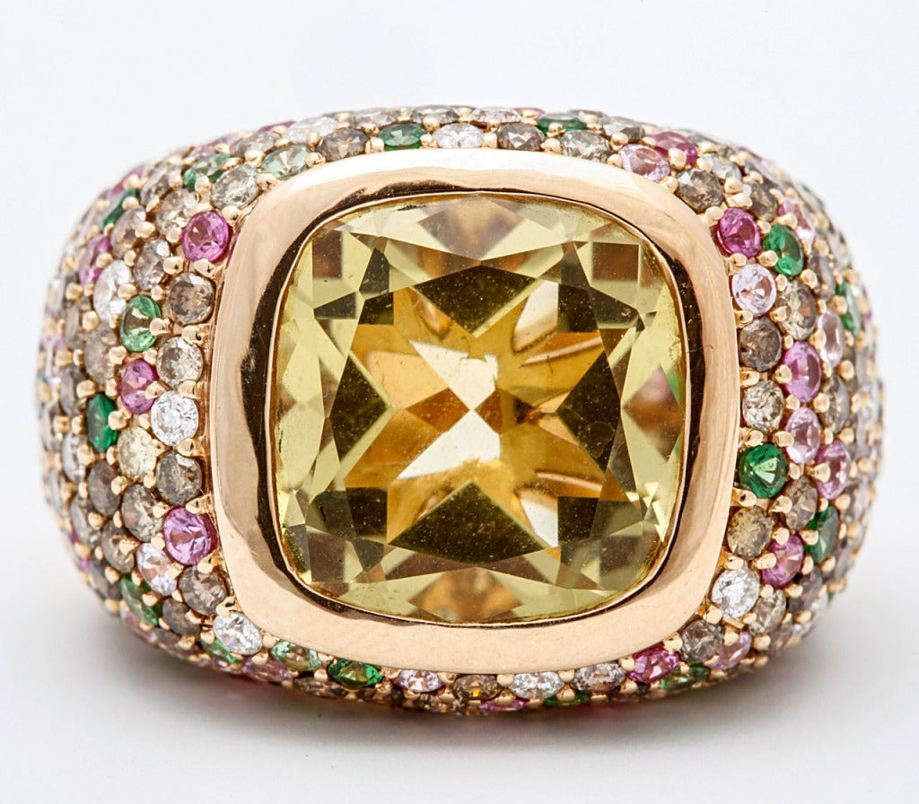 An 18 carat rose gold lemon quartz, tsavorite garnet, pink sapphire and diamond dress ring by Arthur Scholl.
The collet-set cushion-shaped lemon quartz weighing 6.90 carats, to pavé-set surround of brilliant-cut diamonds, tsavorite garnets and pink